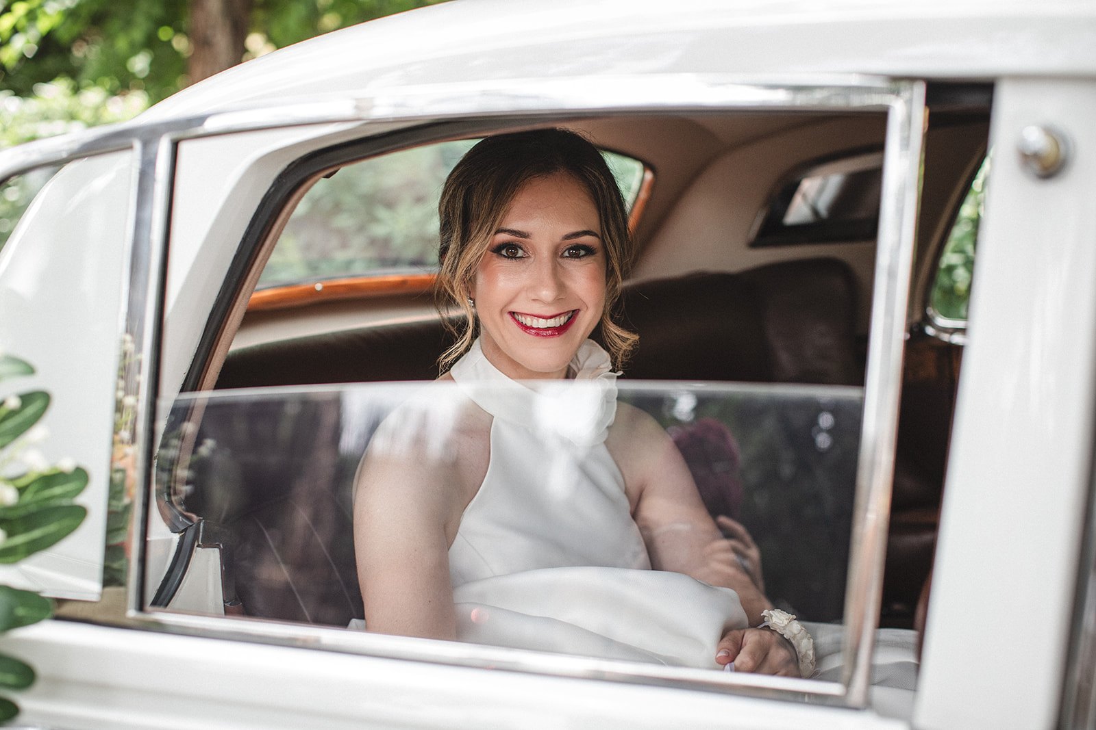Novia sonriendo desde un coche
